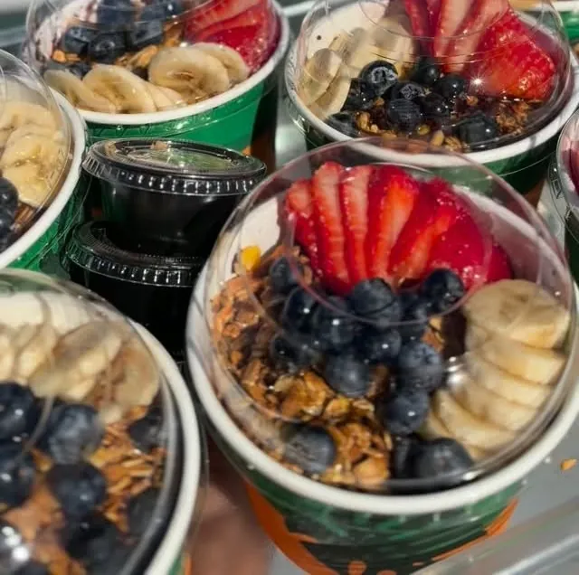 Açaí cups with fruit and granola lined up for an office breakfast